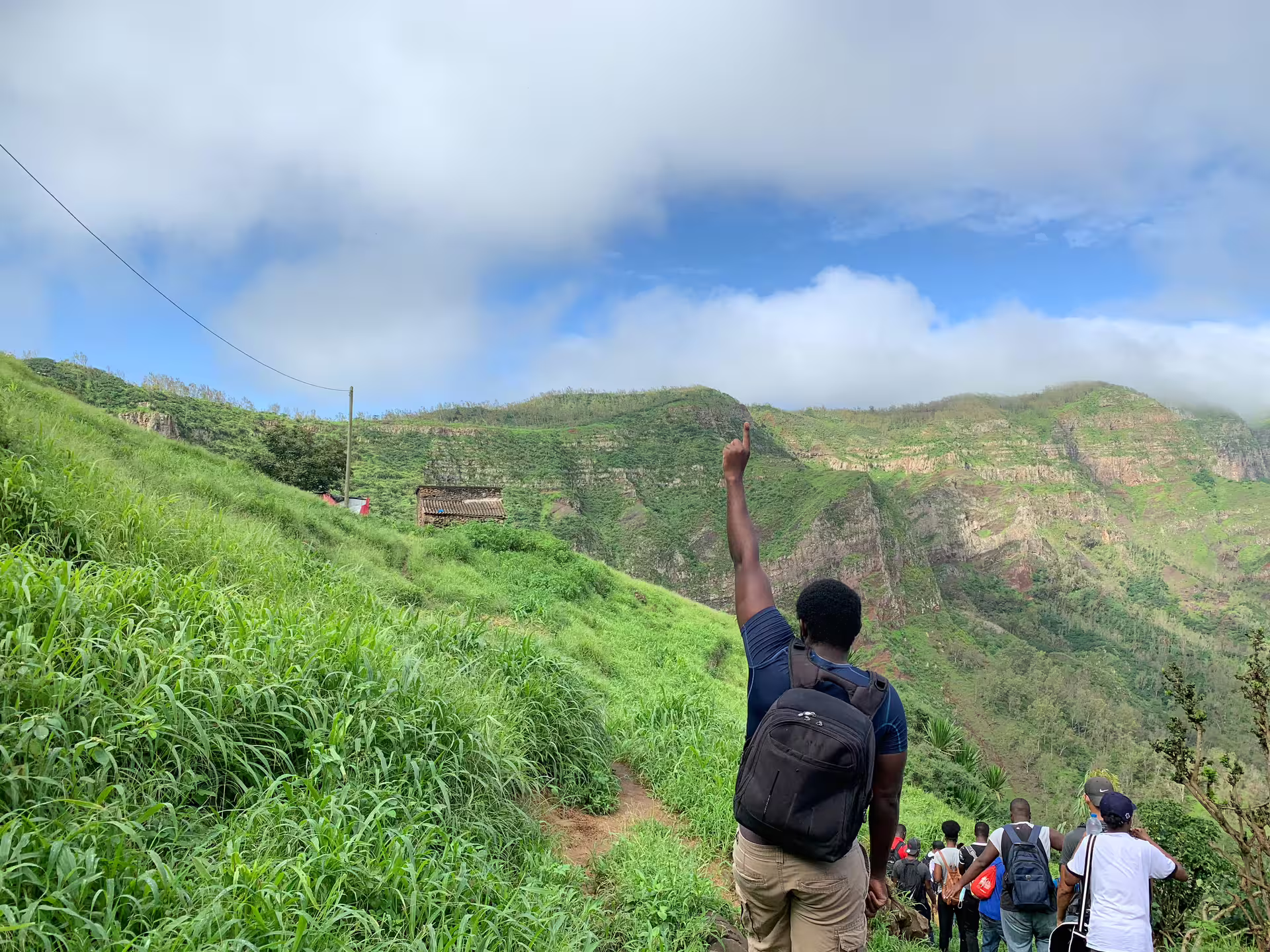 Hikers on the Longueira trail, Santiago Island, enjoying panoramic views and vibrant greenery.