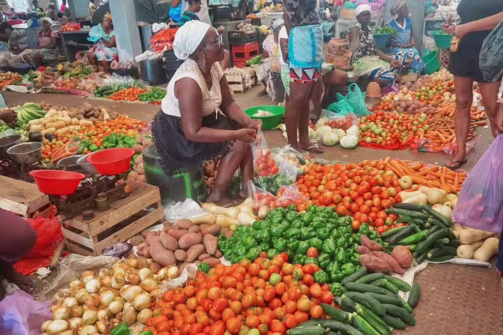 Santiago Island market scene with colorful produce and a local vendor interacting with customers.
