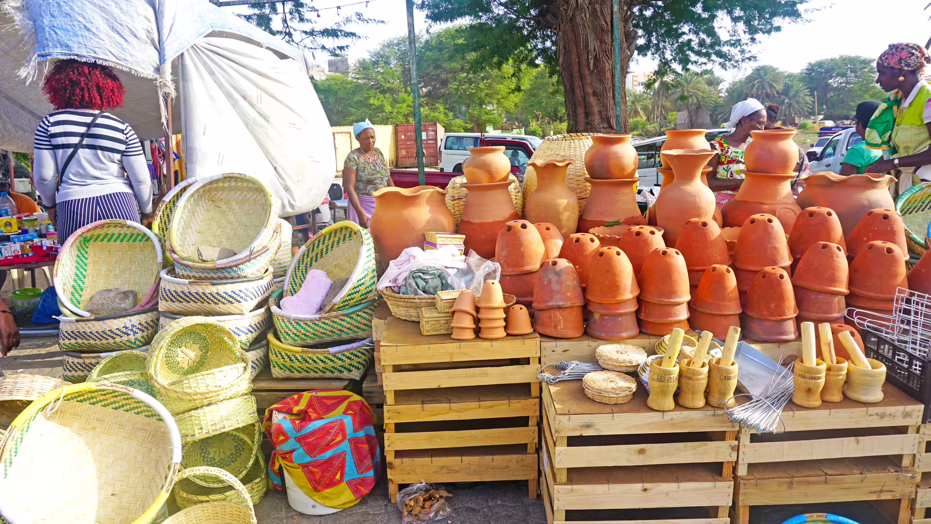 Praia market stall with clay pots and woven baskets, authentic Cape Verde crafts on Santiago Island tour