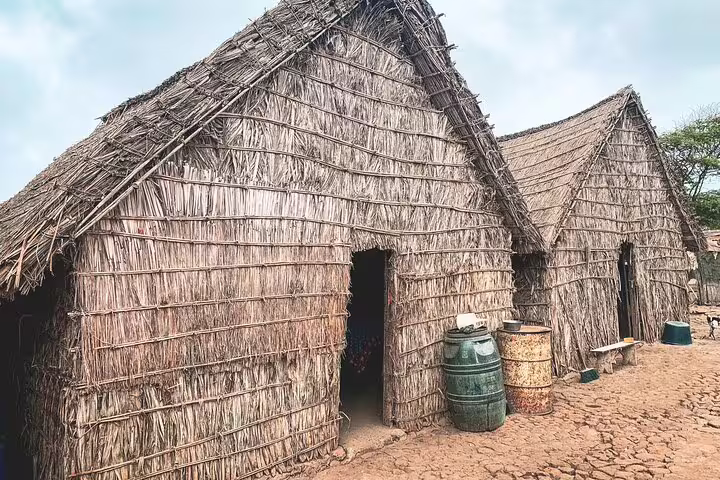 Traditional thatched huts on Santiago Island showcasing local architecture and culture in a rural setting.
