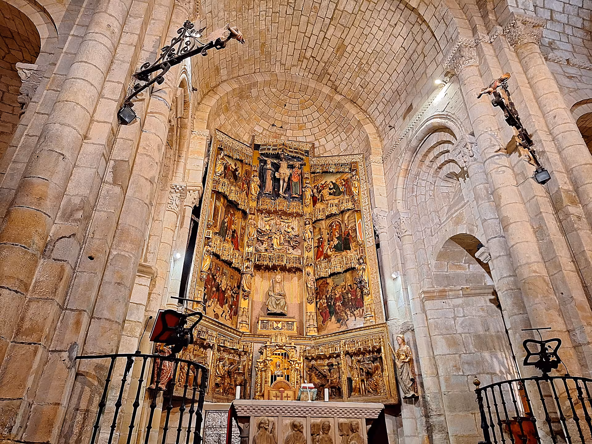 The ornate altarpiece inside a historic church at Santillana del Mar features detailed religious artwork and stone arches.