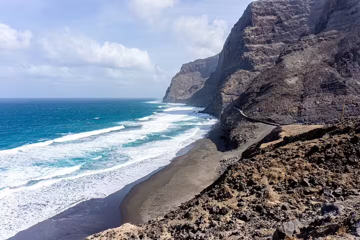 Dramatic coastal cliffs and sandy shores meet the turquoise waters on Santo Antão's Cruzinha hike.