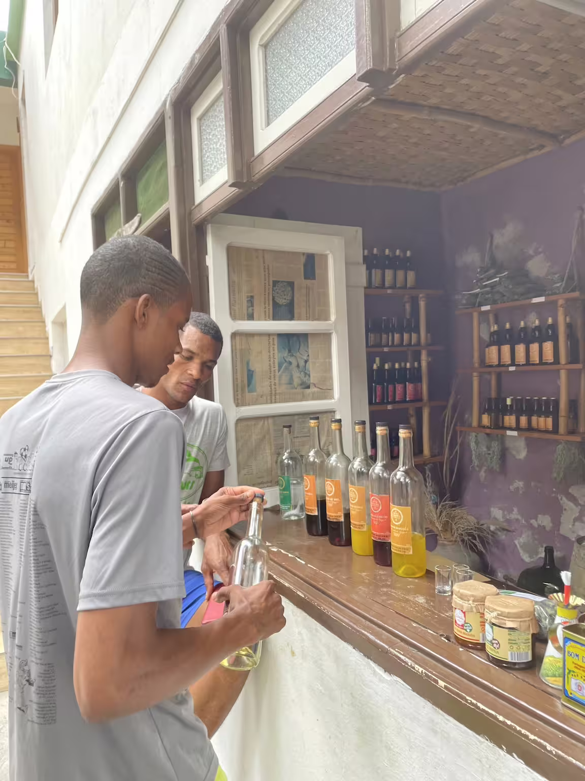 Tourists sample local liqueurs at a quaint tasting stall in Santo Antão's lush Valley of Paul, Cape Verde.