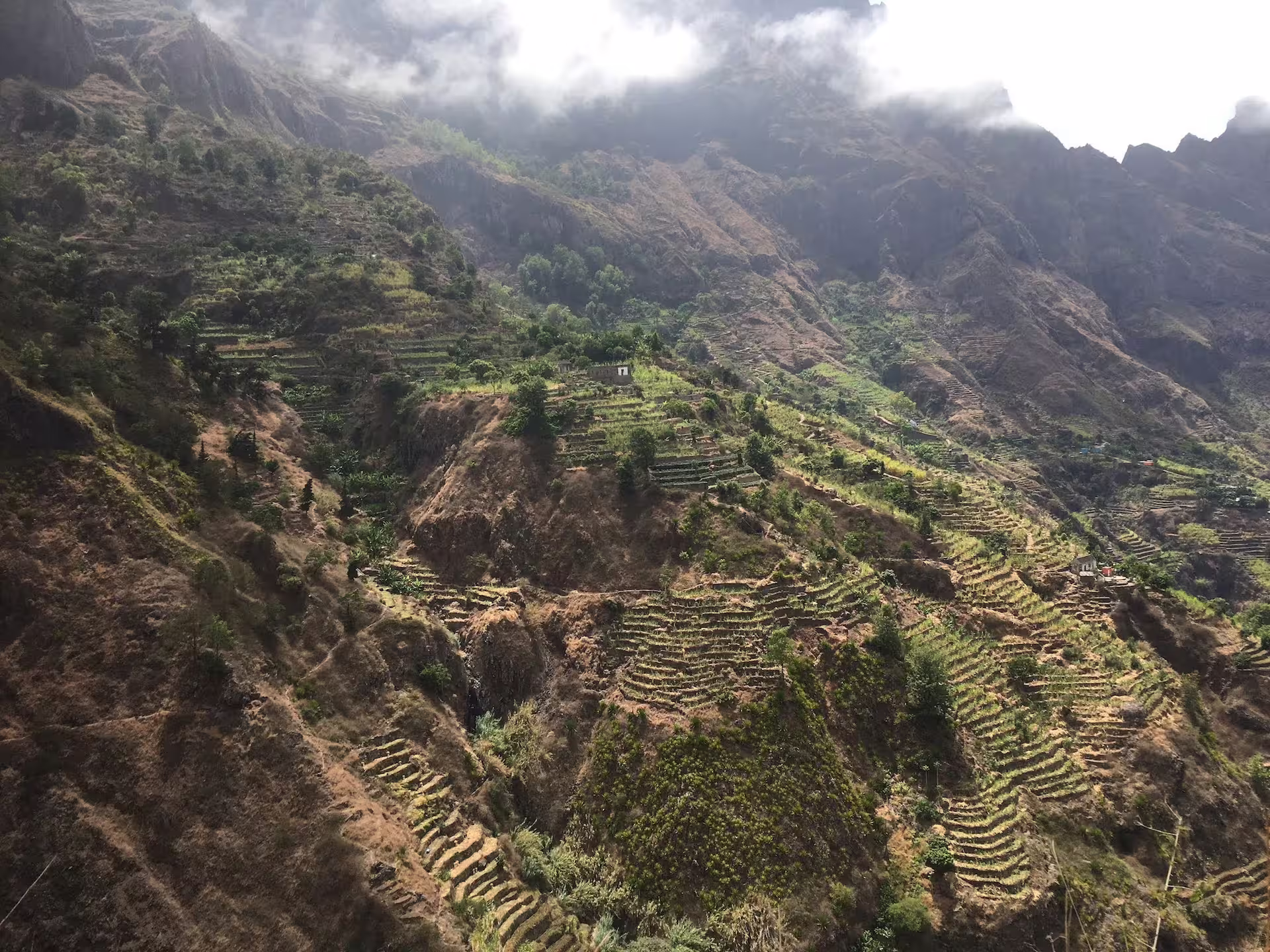 Lush terraced hills and misty mountains of Santo Antão's Valley of Paul, ideal for scenic treks from São Vicente.