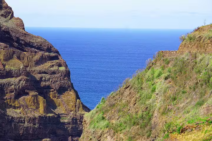 Dramatic coastal cliffs and lush greenery overlooking the Atlantic Ocean in Santo Antão hiking tour.