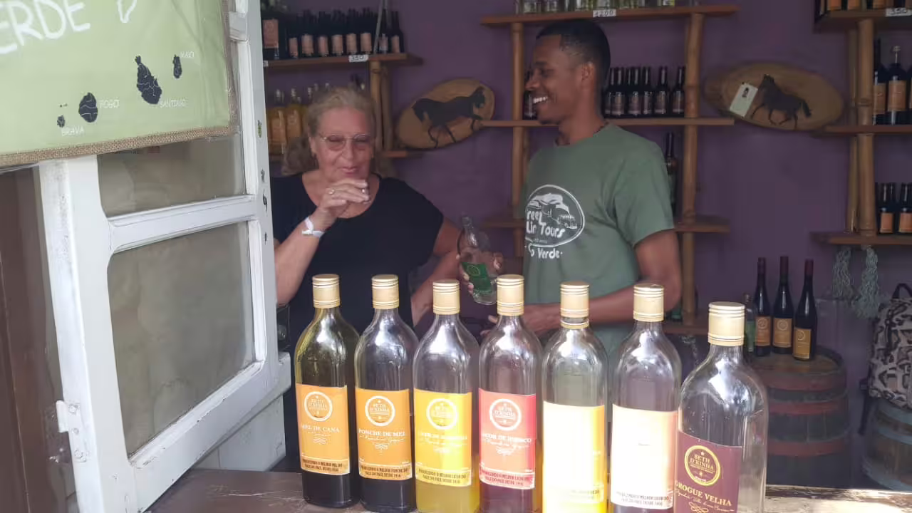 Tourist enjoys a local rum tasting experience during a scenic Santo Antão day trip from São Vicente, Cape Verde tour.