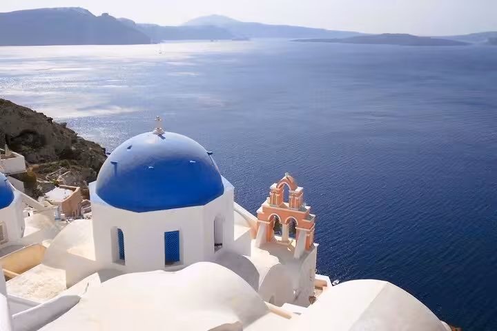 Blue-domed church overlooking Santorini caldera, scenic stop on small-group cruise shore excursion tour