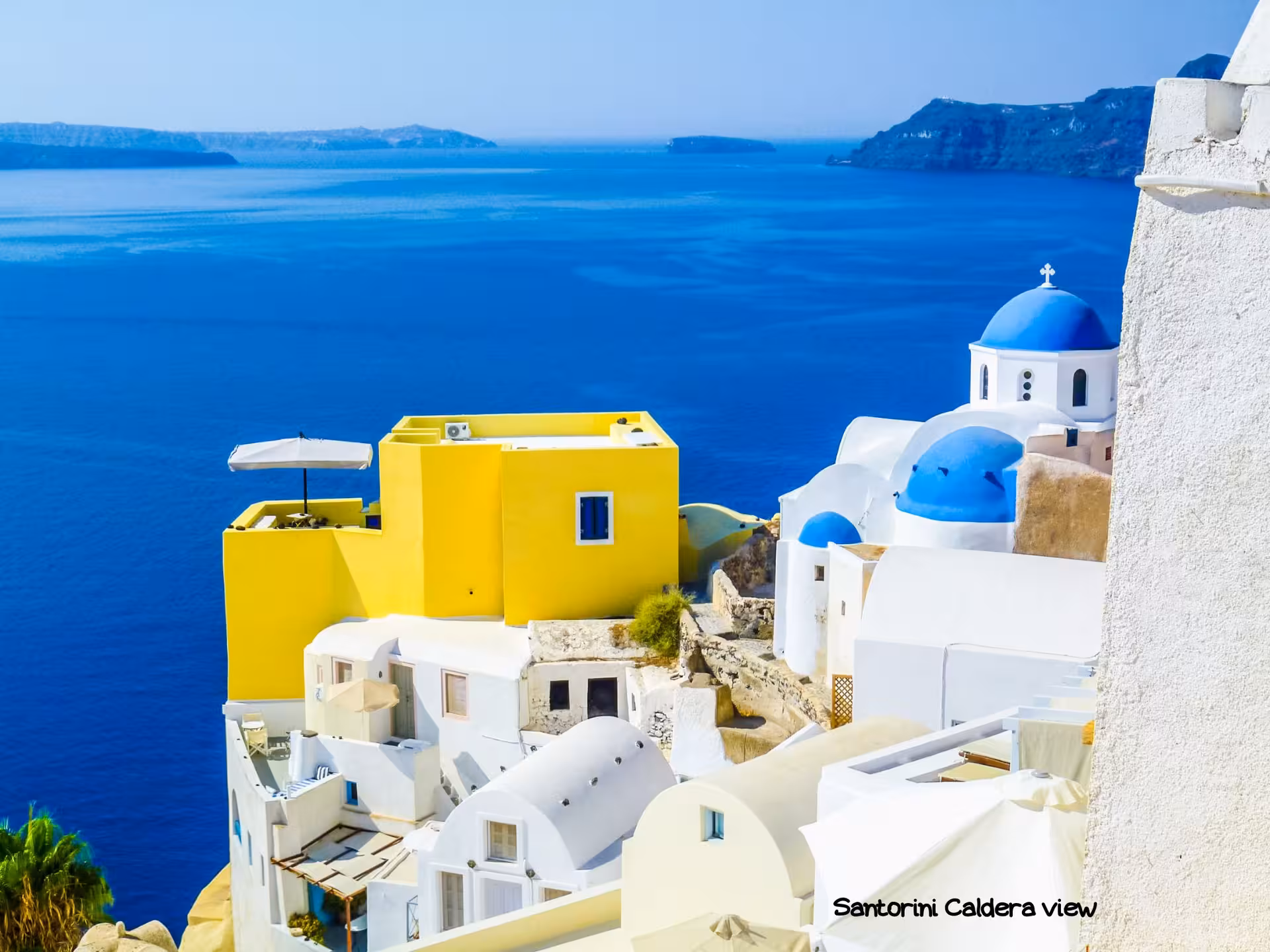Santorini caldera view with blue-domed church and white villas, Athens island hopping to Santorini itinerary