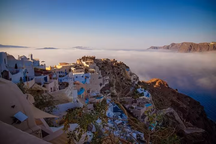 Panoramic Santorini Caldera view with Oia village at sunrise, whitewashed houses on a one-day Santorini tour