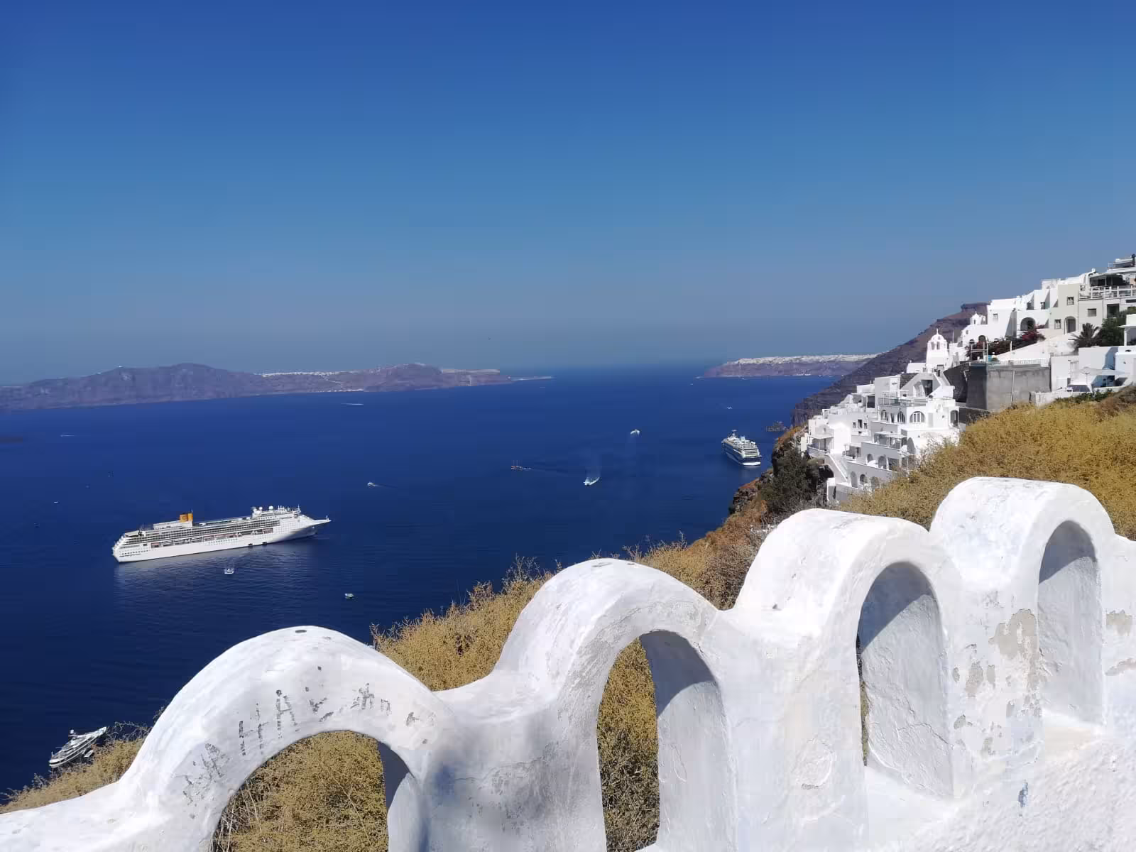 Santorini caldera view with cruise ships below Fira cliffs, ideal Shore to Oia excursion for cruise guests