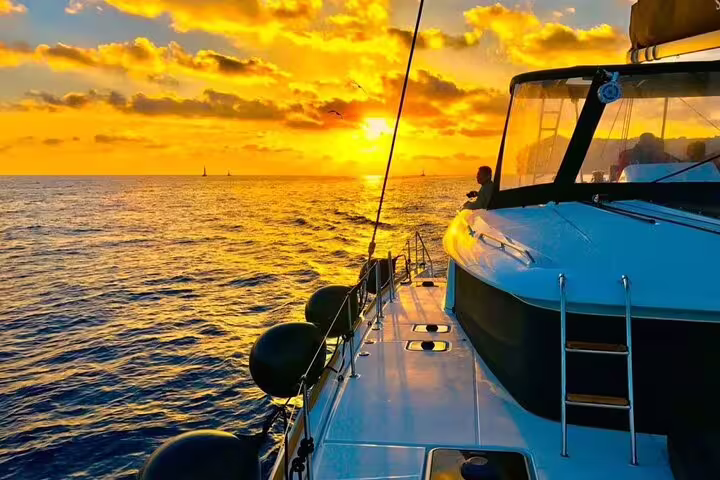 Breathtaking sunset view from a catamaran on the Aegean Sea during a Santorini half-day cruise with meal.