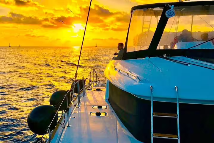 Stunning sunset over the Aegean Sea from a catamaran deck during a private cruise in Santorini.