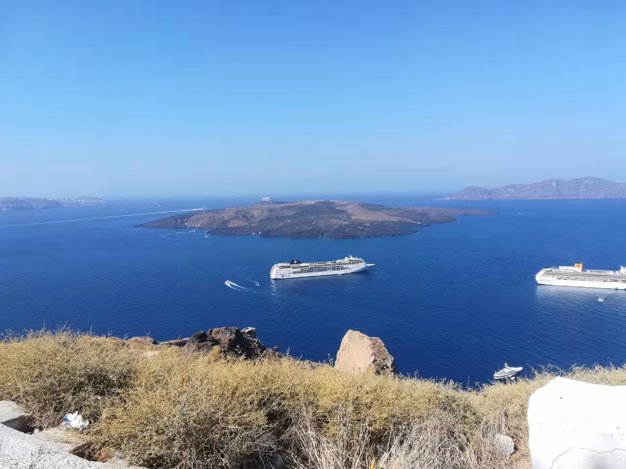 Cruise ships anchored in Santorini caldera by volcanic islets, perfect shore excursion to Oia for cruise passengers