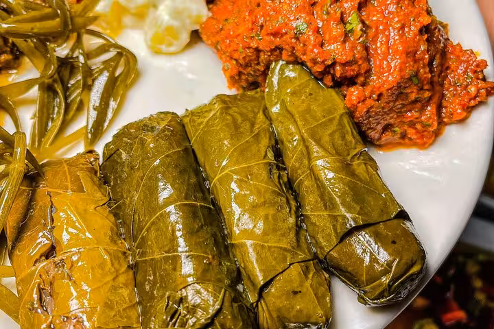 Traditional Greek dolmadakia vine leaves with sauce, served as a tasting during Santorini cooking experience