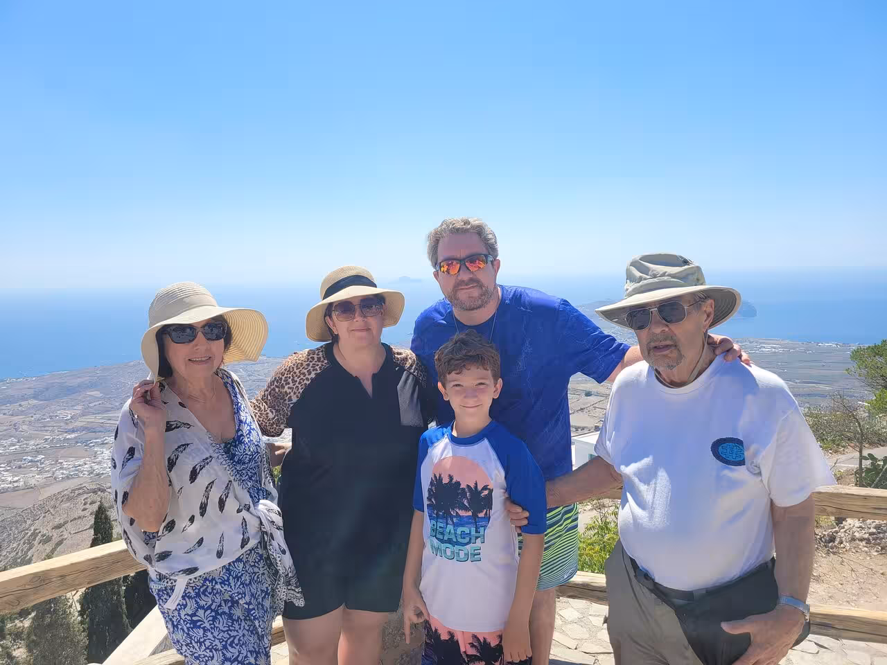 Family at Prophet Elias viewpoint overlooking Santorini and the Aegean on a private highlights shore excursion