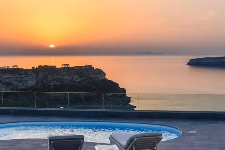 Santorini caldera sunset from luxury villa pool deck with loungers, perfect day getaway package with transport