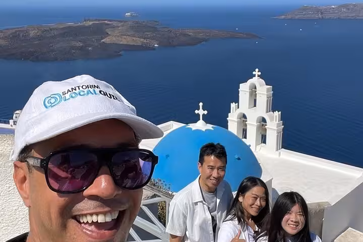 Santorini cruise shore excursion photo at Oia blue dome church viewpoint overlooking the caldera and Aegean Sea