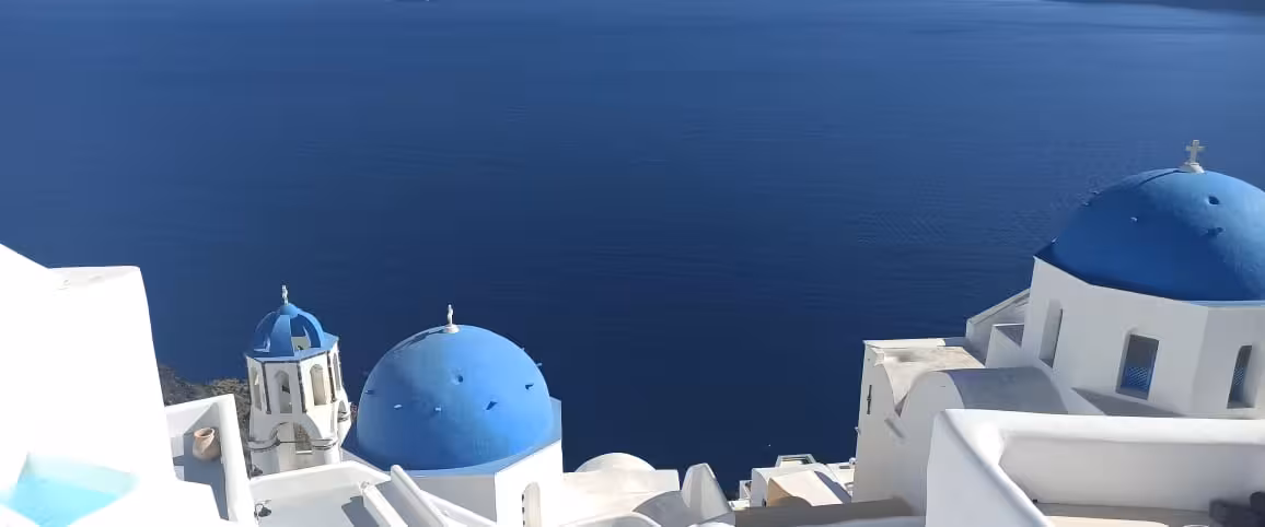 Oia blue-domed churches overlooking Santorini caldera, highlight stop on 5-hour shore to Oia cruise guest tour