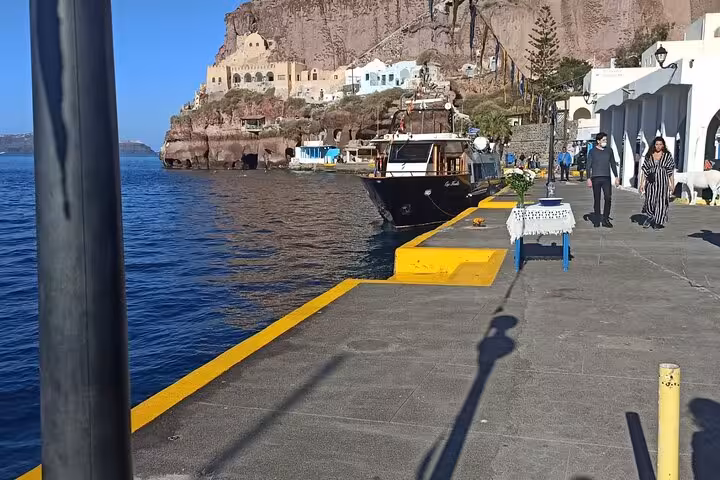 Old port waterfront in Santorini with boat and promenade, pickup point for Oia highlights cruise excursion