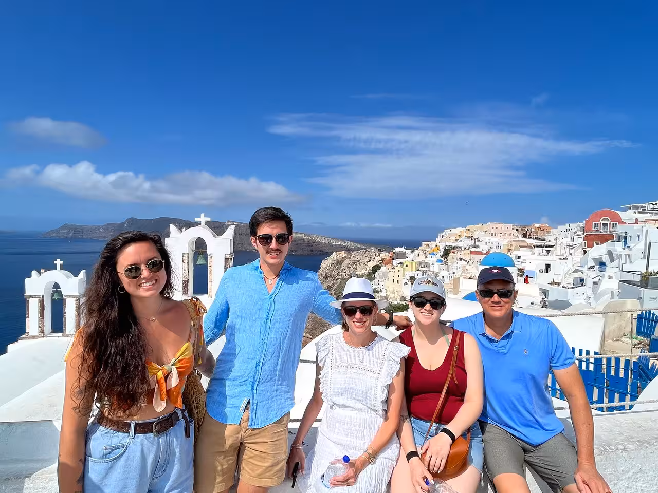 Happy group in Oia with white churches and caldera views on a Santorini highlights private shore excursion
