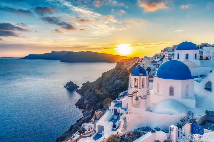 Santorini Oia sunset with blue-domed church and caldera views, perfect 2-day tour from Athens