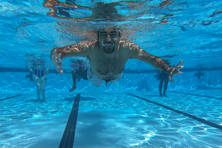 Underwater shot of a swimmer in a Santorini private pool, ideal for a caldera-view day and sunset swim experience