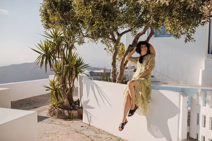 Relaxing at a quiet Santorini terrace with olive trees, a hidden-gem photo stop on a private SUV tour
