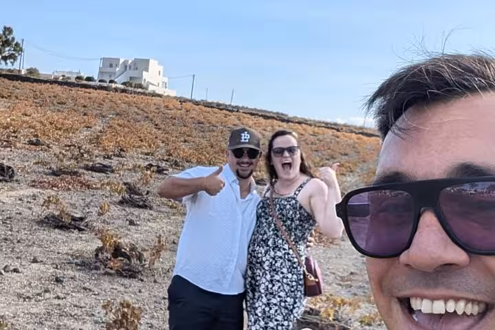 Happy guests in Santorini vineyard during private wine tasting tour, visiting 2–4 wineries with local snacks