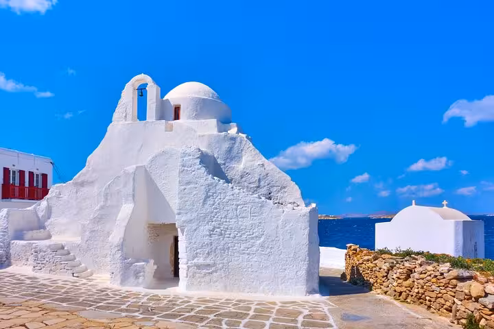 Santorini whitewashed church with blue sky and sea view, iconic stop on a 2-day Athens to islands tour