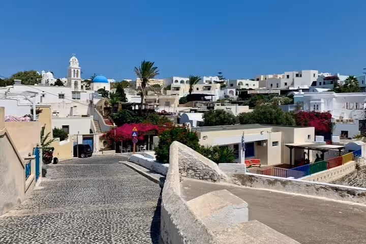 Cobblestone lane in Santorini village with whitewashed houses, ideal stop on Athens private tour and wine tasting