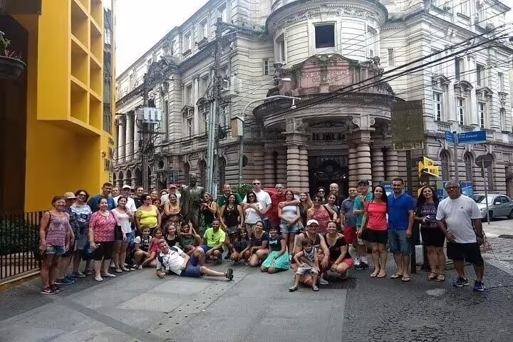 Group of tourists exploring historic streets of Santos during a 10-hour shared full-day beach tour with lunch.