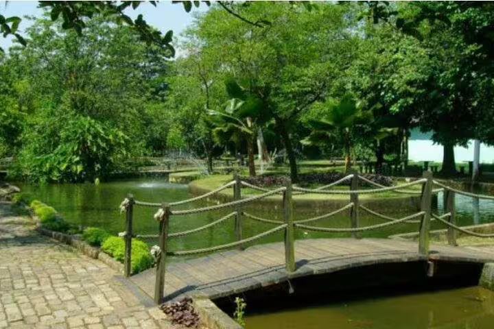 Scenic garden pathway with wooden bridge and lush greenery, featured in the 7-hour Santos sightseeing tour.