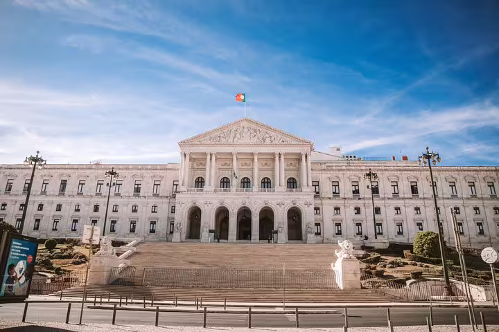 Majestic São Bento Palace under a clear sky, highlighting Lisbon's historical landmarks on a tuk-tuk tour.