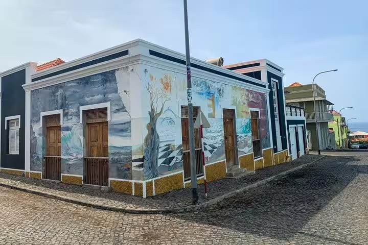 Colorful mural depicting artistic scenes on a building in São Filipe's historic district, ideal for cultural walking tours.