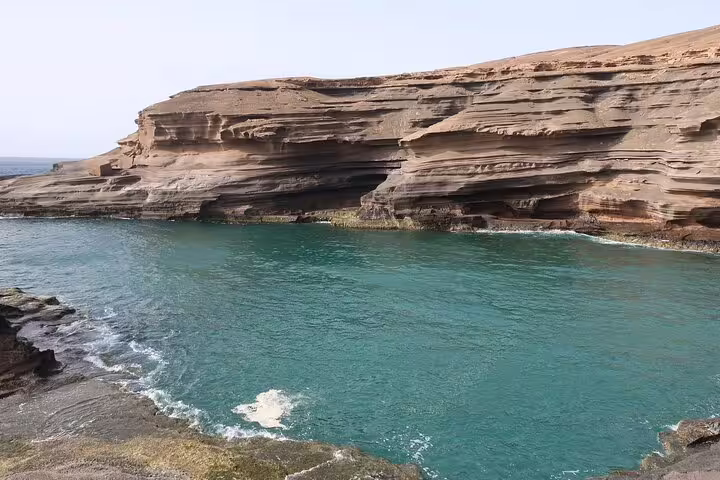 Stunning view of Carbeirinho's natural rocky cliffs and turquoise waters along the São Nicolau hiking trail.