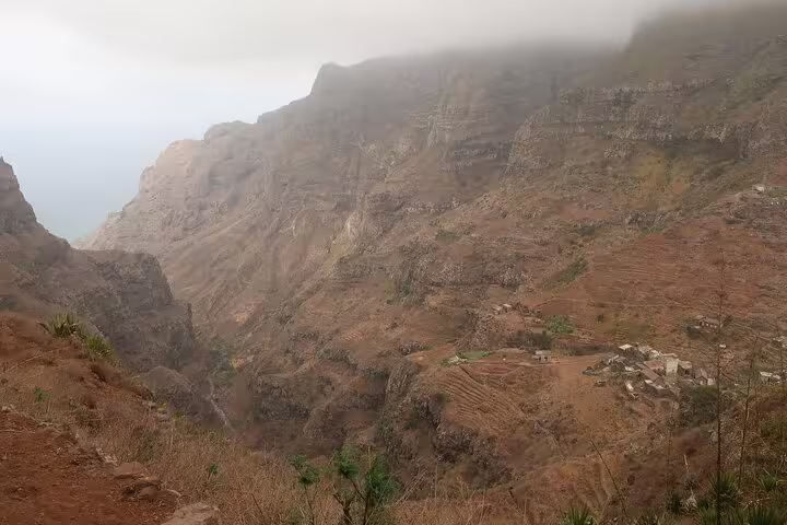 Dramatic view of São Nicolau's Fajã cliffs shrouded in mist, ideal for adventurous hiking and nature exploration.