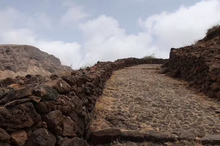 Cobblestone path lined with stone walls leads through São Nicolau's scenic hiking route Fajã-Covoada-Fajã.