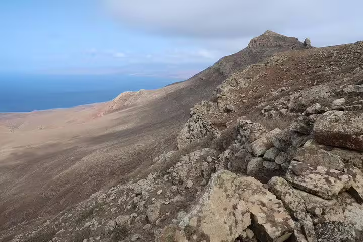Expansive view from São Nicolau's Juncalinho Trail showcasing rugged terrain and distant ocean horizon.