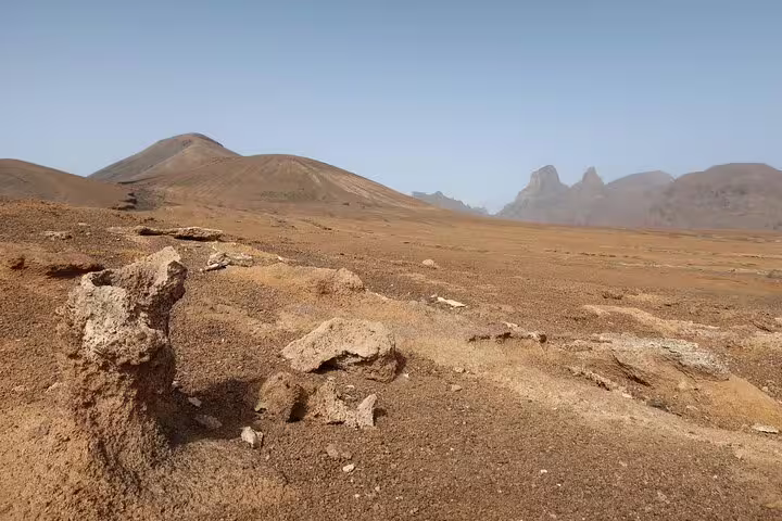 Rocky terrain and distant peaks in São Nicolau's Praia Branca, ideal for adventurous hiking tours.