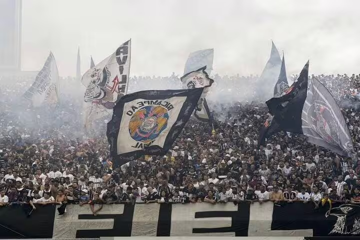 Passionate football fans with flags and smoke create an electrifying atmosphere at São Paulo's stadium experience.