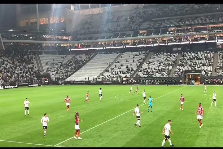 Players in action on the field at São Paulo's stadium, offering an authentic football experience with a guided tour.