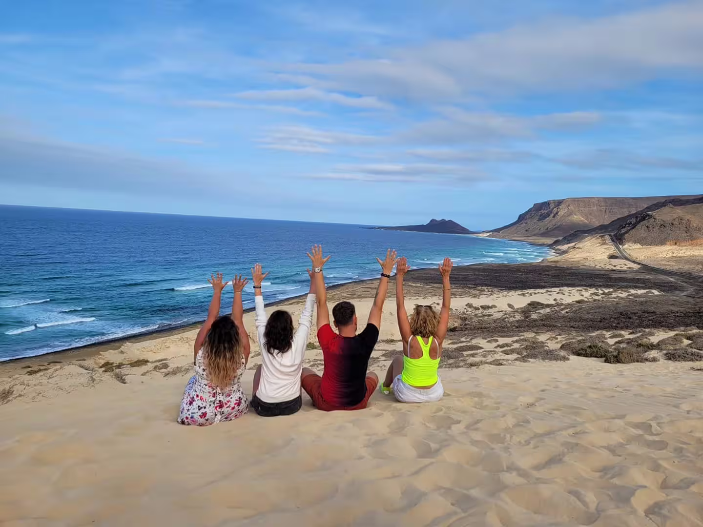 Tourists enjoy panoramic ocean views from a sandy hill during a full-day tour of beaches and Monte Verde, São Vicente.