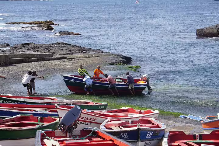 Locals launching a fishing boat at a vibrant harbor in São Vicente, showcasing maritime traditions and coastal culture.