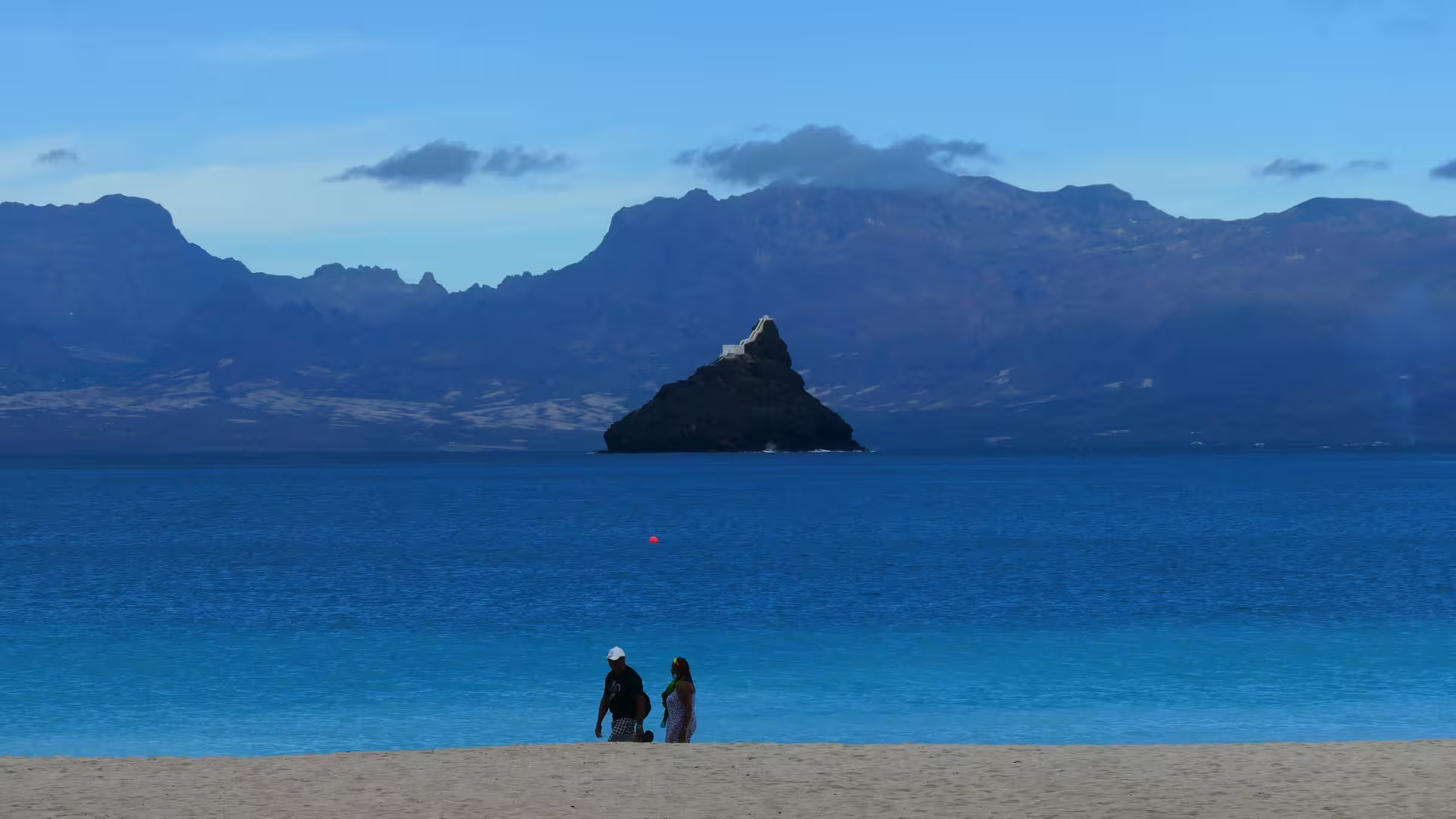 Couple strolling on a pristine beach with scenic views of São Vicente Island's mountains and ocean.