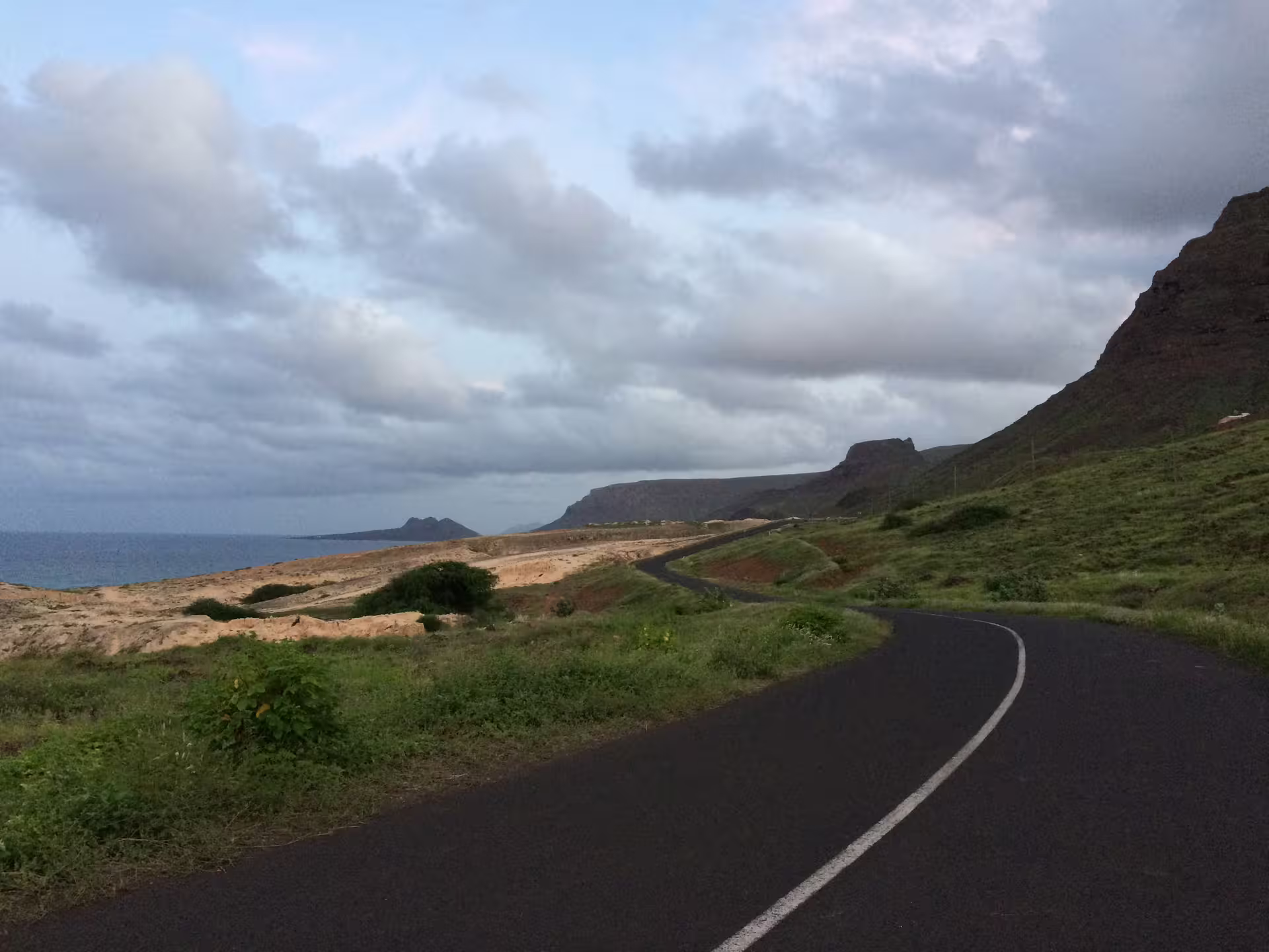 Scenic coastal road in São Vicente with lush green landscapes and ocean views on a full day shore excursion in Mindelo.