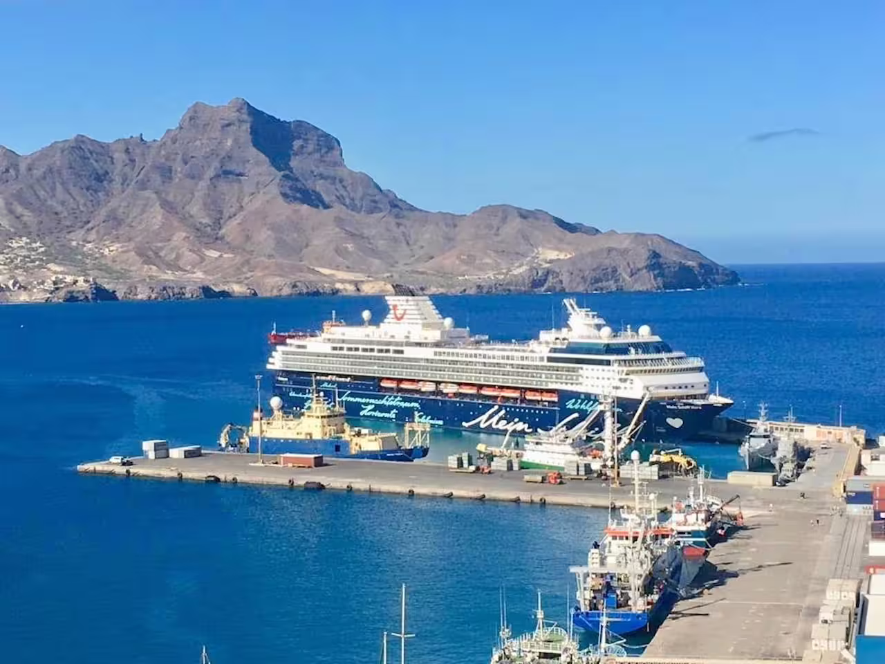 Cruise ship docked at Mindelo port in São Vicente with stunning mountainous backdrop, ideal for full day shore excursions.