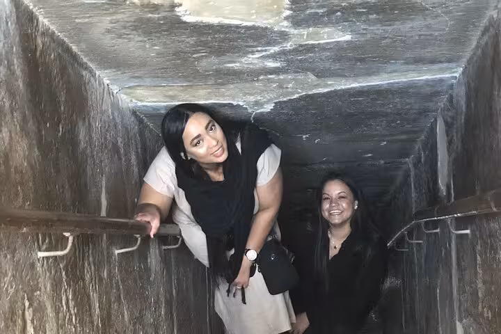 Visitors descending into a Saqqara pyramid passage on a private all-inclusive tour from Cairo to Dahshur and Memphis