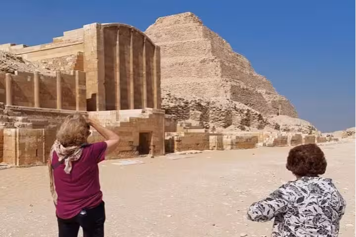 Travelers viewing Saqqara Step Pyramid and ruins near Memphis, Egypt day tour with pyramid entry and lunch