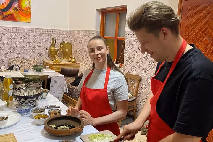 Participants enjoy hands-on learning at Sardin Tawa Cooking Class in Marrakesh, perfecting Moroccan culinary skills.