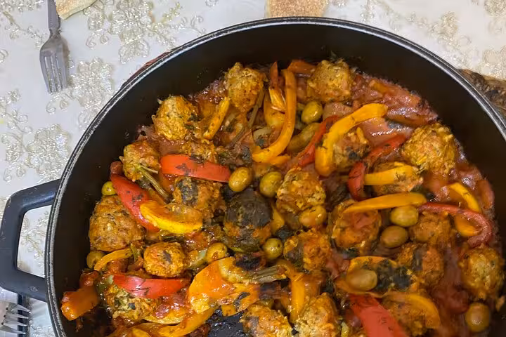 A vibrant Moroccan dish with meatballs, peppers, and olives prepared during the Sardin Tawa Cooking Class in Marrakesh.